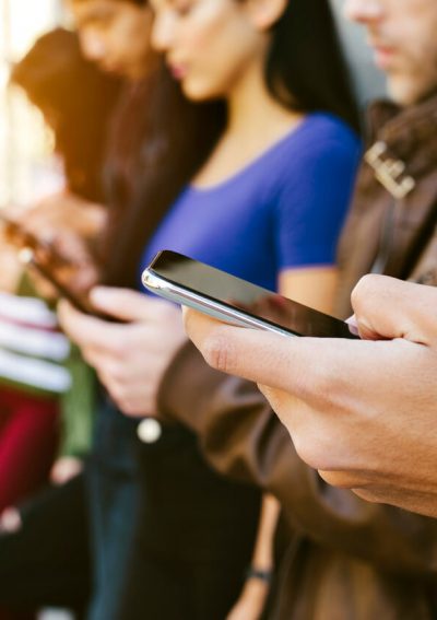 Row of young adults on cellphones