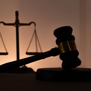 Silhouettes of a judge's gavel and scales of justice. Symbol of law, rights, legal protection, and the court.