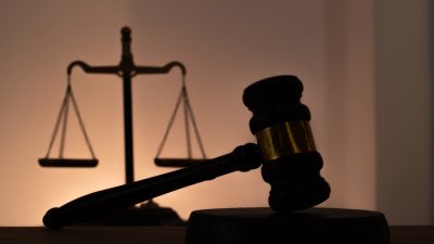 Silhouettes of a judge's gavel and scales of justice. Symbol of law, rights, legal protection, and the court.