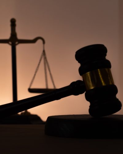 Silhouettes of a judge's gavel and scales of justice. Symbol of law, rights, legal protection, and the court.