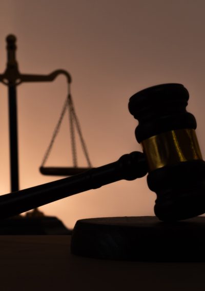Silhouettes of a judge's gavel and scales of justice. Symbol of law, rights, legal protection, and the court.
