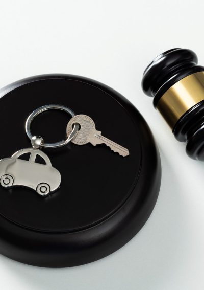 Gavel and car key on white background.
