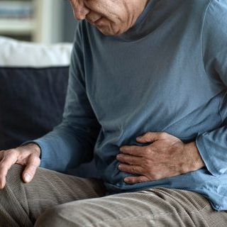 Man clutching his stomach in pain