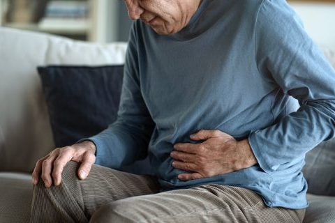 Man clutching his stomach in pain