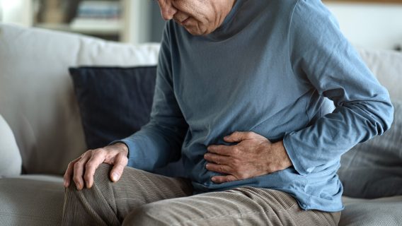 Man clutching his stomach in pain