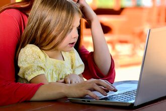 Mom and her child using laptop together