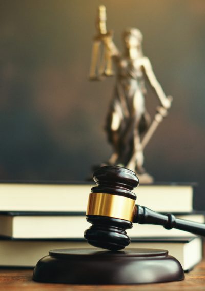 Gavel on desk with law books and Lady Justice.