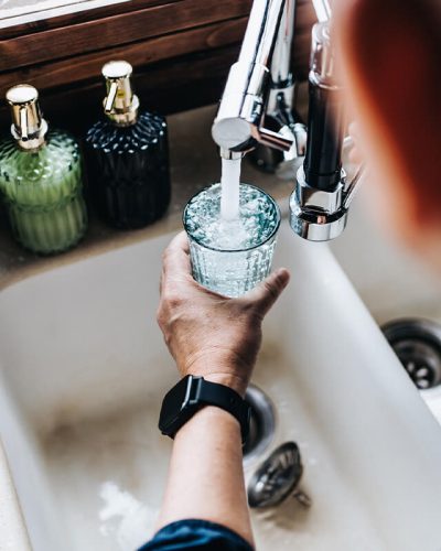 Someone filling a glass with tap water.