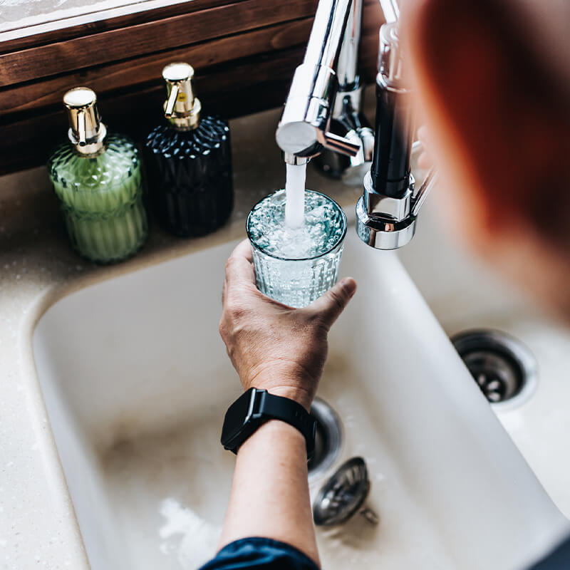 Someone filling a glass with tap water.