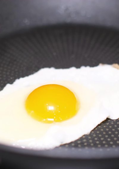 Egg cooking in frying pan.