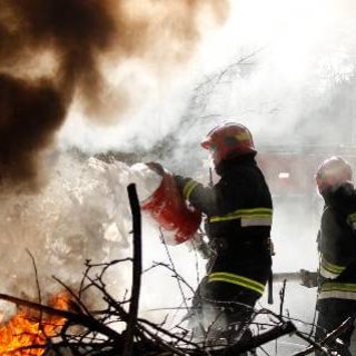 Firefighters using foam on flames