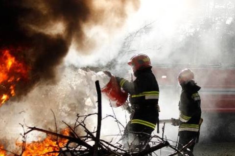 Firefighters using foam on flames