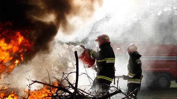 Firefighters using foam on flames