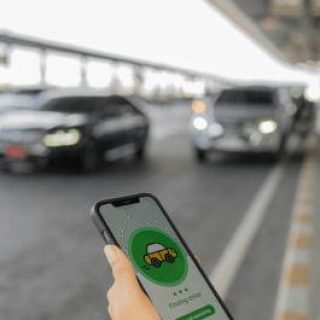 person-using-rideshare-app-while-waiting-outside-of-airport