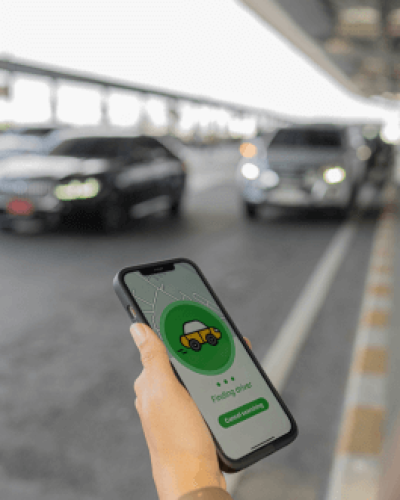 person-using-rideshare-app-while-waiting-outside-of-airport