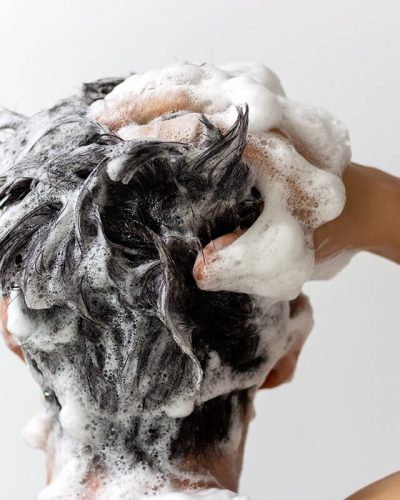 Person washing hair with shampoo