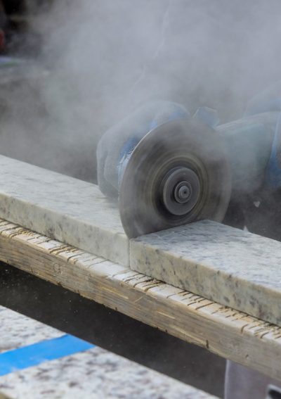 Marble cutting at construction site close up industrial tool, grinder piece of granite stone