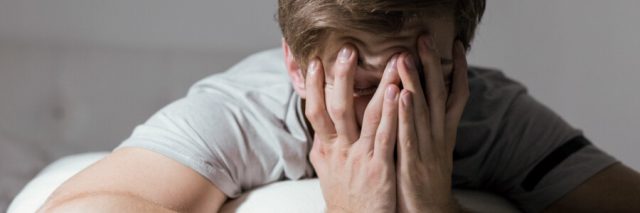 Man holding face from sleep apnea