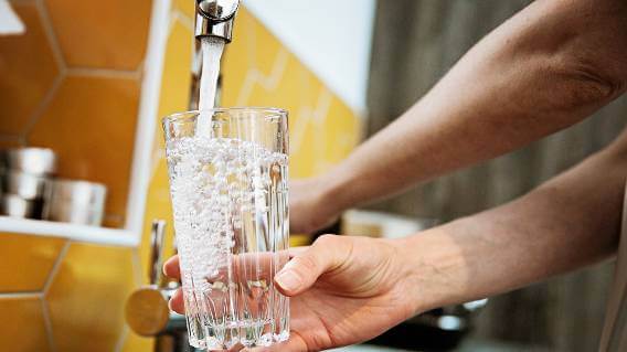 Water running into glass from tap