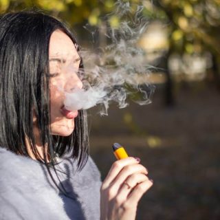 Teen girl vaping with e-cigarette