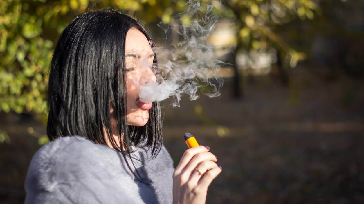 Teen girl vaping with e-cigarette