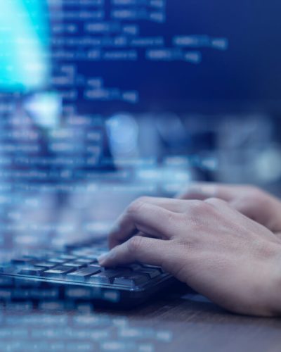 Close-up of man's hand typing on a keyboard.