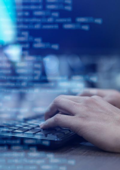 Close-up of man's hand typing on a keyboard.