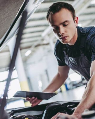 man performing a vehicle safety inspection