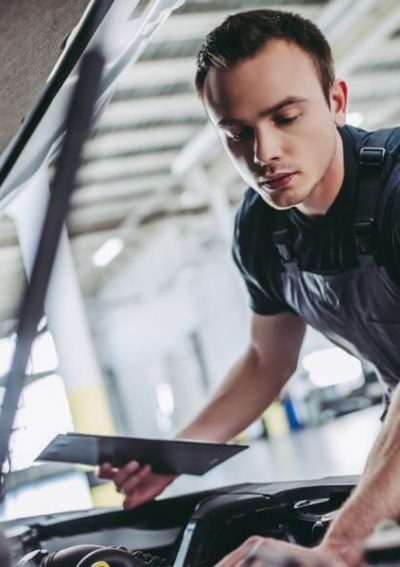 man performing a vehicle safety inspection