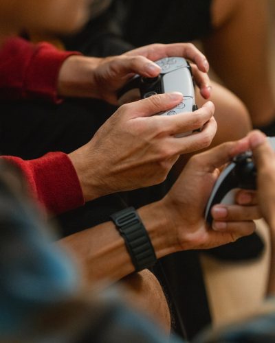 Group of friends immersed in a football video game, each holding their game controllers with focus and excitement as they compete and cheer in the heat of the match, enjoying the thrill of friendly competition and shared laughter