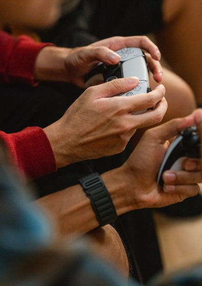 Group of friends immersed in a football video game, each holding their game controllers with focus and excitement as they compete and cheer in the heat of the match, enjoying the thrill of friendly competition and shared laughter