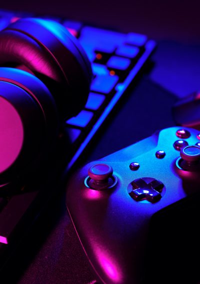 Headphones, joystick and computer keyboard on black table close up