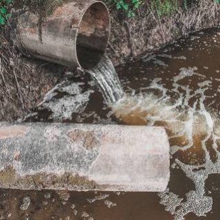 Water flowing from pipe into river