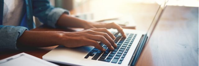 woman's hands typing on laptop keyboard