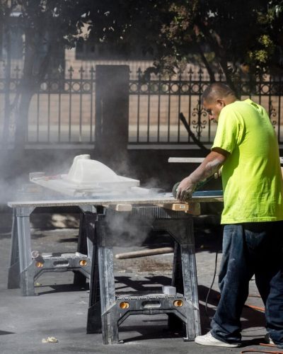 Worker cutting granite without protection.